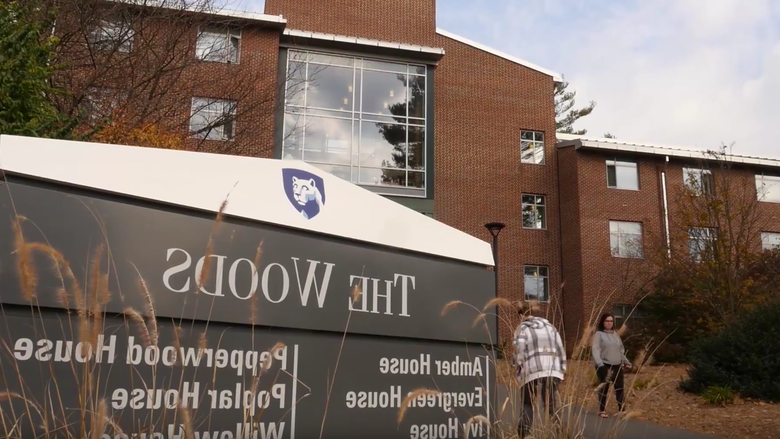 Shot of "The Woods" sign outside the residence halls on campus